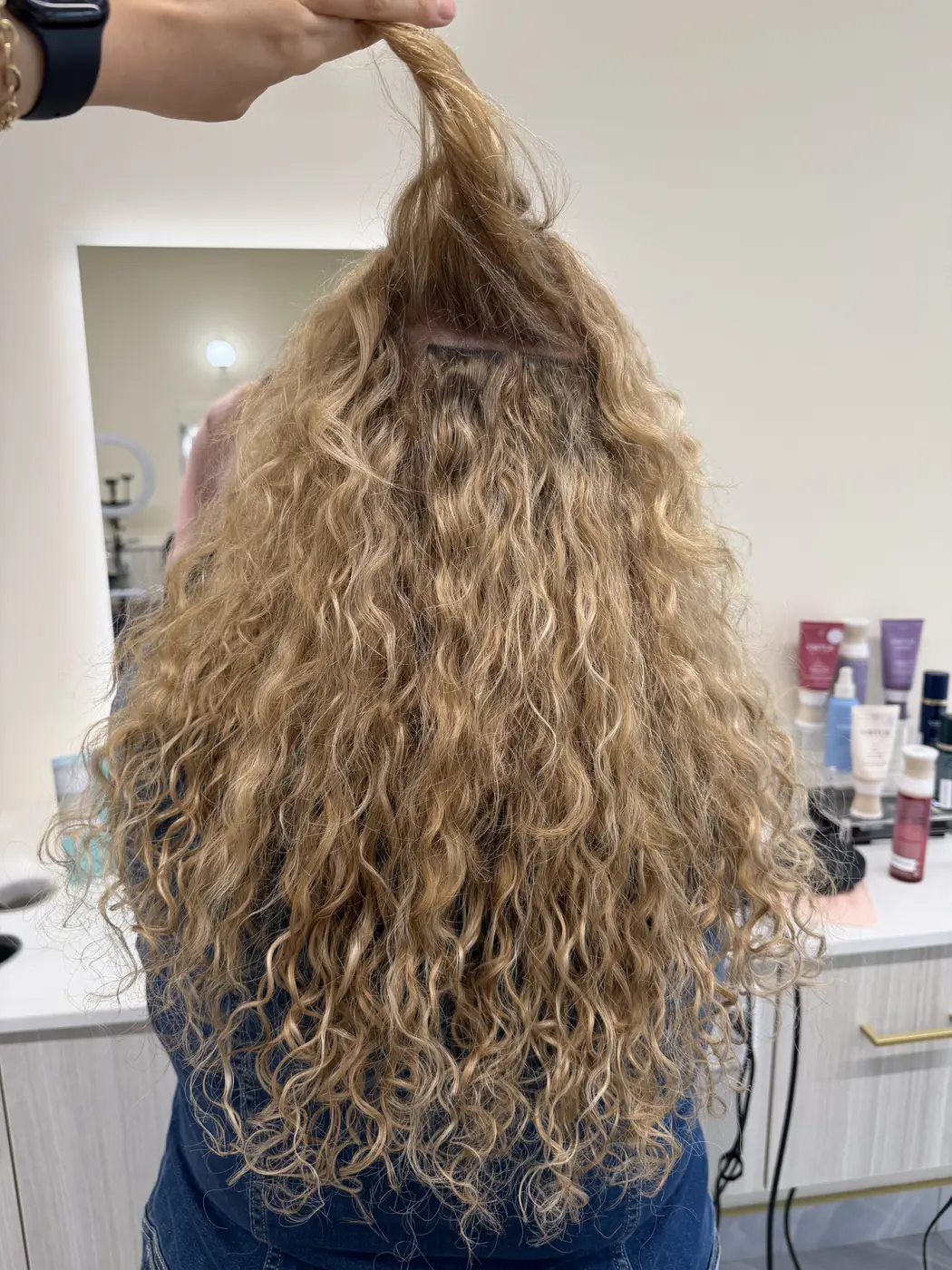 Tape-in hair extensions blended into natural curly hair at Salon Dain Toronto